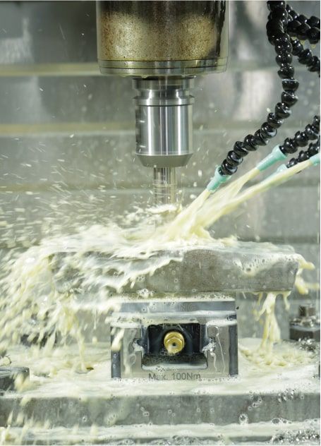 Milling cutter machining a metal component with coolant